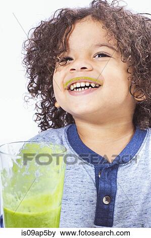 Boy drinking green smoothie with messy lips View Large Photo Image Stock Photo - Boy drinking green smoothie with messy lips. Fotosearch