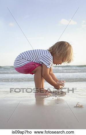 Boy exploring on the beach at sunset View Large Photo Image Picture - Boy exploring on the beach at sunset. Fotosearch