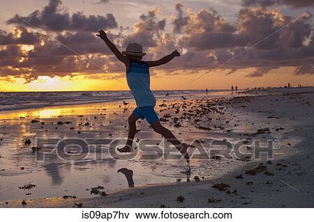 Boy exploring on the beach at sunset View Large Photo Image Stock Photo - Boy exploring on the beach at sunset. Fotosearch