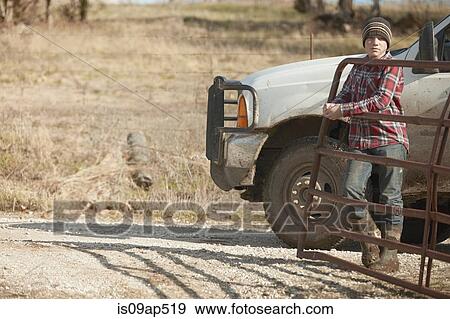 Boy farmer opening gate for truck on dairy farm View Large Photo Image Stock Photo - Boy farmer opening gate for truck on dairy farm. Fotosearch
