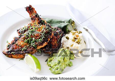 Stock Image - "Brick chicken - roasted chicken with stuffed pepper, guacamole and potatoes". Fotosearch