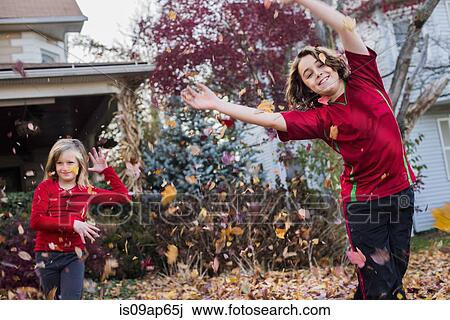 Brother and sister playing with autumn leaves in garden View Large Photo Image Stock Image - Brother and sister playing with autumn leaves in garden. Fotosearch