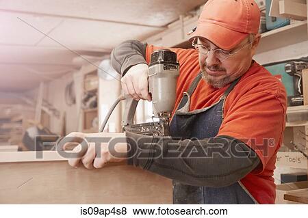 Cabinet maker using electric drill in workshop View Large Photo Image Stock Photo - Cabinet maker using electric drill in workshop. Fotosearch