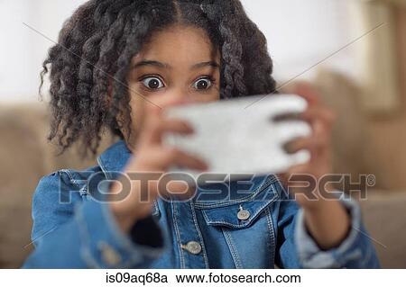 Close up of cute girl looking surprised for smartphone selfie View Large Photo Image Stock Image - Close up of cute girl looking surprised for smartphone selfie. Fotosearch