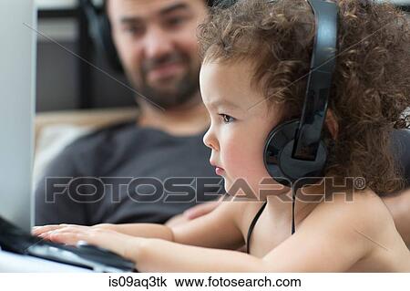 Close up of female toddler typing on laptop whilst father watches View Large Photo Image Stock Image - Close up of female toddler typing on laptop whilst father watches. Fotosearch