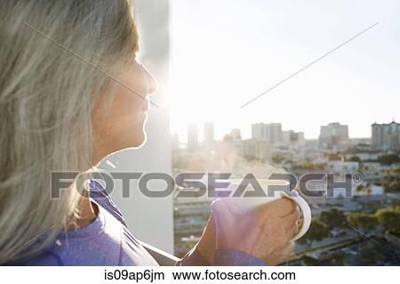 Close up of mature woman drinking coffee on city apartment balcony View Large Photo Image Picture - Close up of mature woman drinking coffee on city apartment balcony. Fotosearch