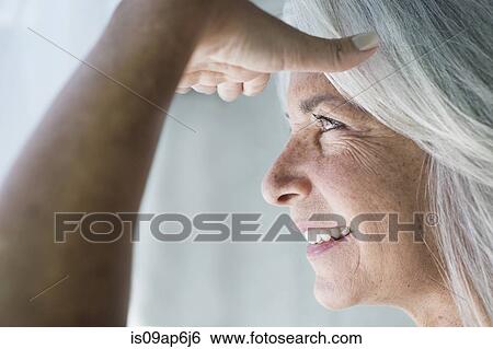 Close up of mature woman with hand shielding eyes View Large Photo Image Stock Photograph - Close up of mature woman with hand shielding eyes. Fotosearch