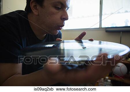 Close up of young man blowing surface of vinyl record View Large Photo Image Stock Image - Close up of young man blowing surface of vinyl record. Fotosearch