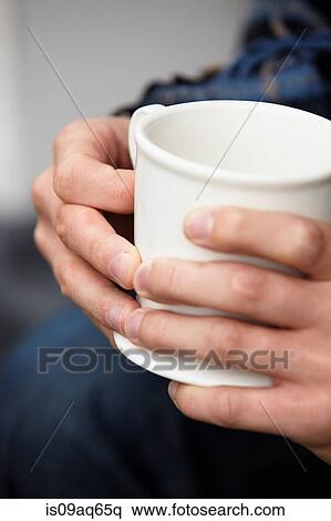 Close up of young mans hands holding coffee mug View Large Photo Image Stock Photography - Close up of young mans hands holding coffee mug. Fotosearch
