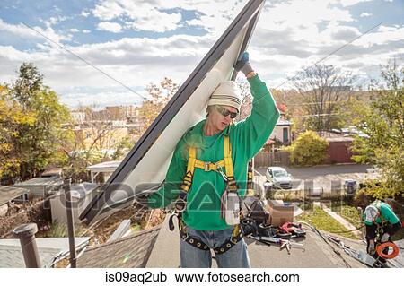 Construction crew carrying a solar panel on roof of house View Large Photo Image Stock Image - Construction crew carrying a solar panel on roof of house. Fotosearch