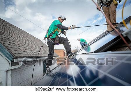 Construction crew installing solar panels on a house View Large Photo Image Stock Image - Construction crew installing solar panels on a house. Fotosearch