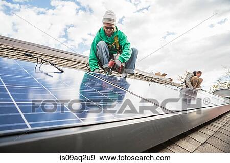 Construction crew installing solar panels on a house View Large Photo Image Stock Photo - Construction crew installing solar panels on a house. Fotosearch