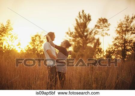Couple hugging in field View Large Photo Image Stock Image - Couple hugging in field. Fotosearch