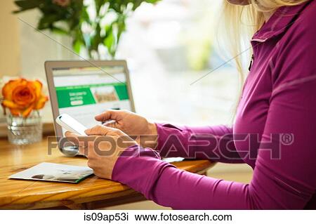 Cropped shot of woman working in kitchen using smartphone View Large Photo Image Stock Image - Cropped shot of woman working in kitchen using smartphone. Fotosearch