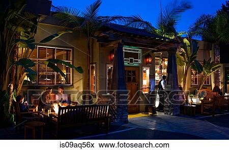 Customers dining out by restaurant open fire View Large Photo Image Stock Photo - Customers dining out by restaurant open fire. Fotosearch
