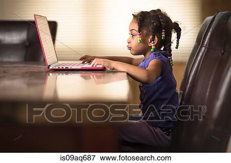 Cute girl at dining table using laptop View Large Photo Image Stock Photo - Cute girl at dining table using laptop. Fotosearch
