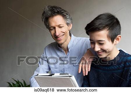 Father and teenage son reading digital tablet View Large Photo Image Stock Photo - Father and teenage son reading digital tablet. Fotosearch
