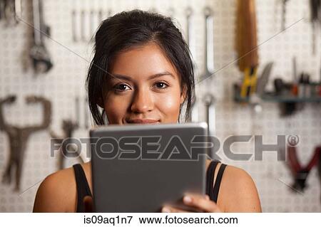 "Female mechanic in workshop, using digital tablet" View Large Photo Image Stock Photo - "Female mechanic in workshop, using digital tablet". Fotosearch