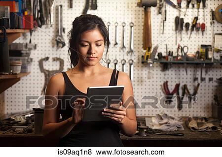 "Female mechanic in workshop, using digital tablet" View Large Photo Image Stock Photo - "Female mechanic in workshop, using digital tablet". Fotosearch