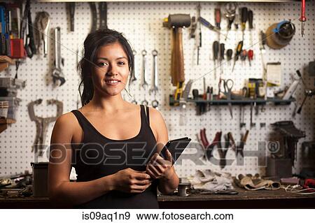 "Female mechanic in workshop, using digital tablet" View Large Photo Image Stock Photo - "Female mechanic in workshop, using digital tablet". Fotosearch