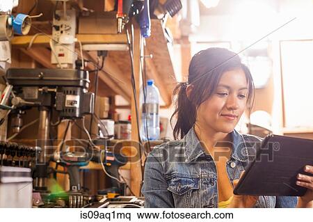 Female mechanic using digital tablet in workshop View Large Photo Image Stock Photography - Female mechanic using digital tablet in workshop. Fotosearch