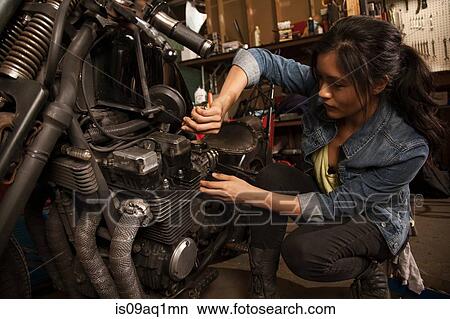 Female mechanic working on motorcycle in workshop View Large Photo Image Picture - Female mechanic working on motorcycle in workshop. Fotosearch