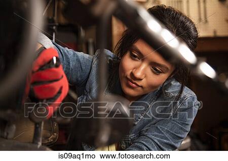 Female mechanic working on motorcycle in workshop View Large Photo Image Picture - Female mechanic working on motorcycle in workshop. Fotosearch