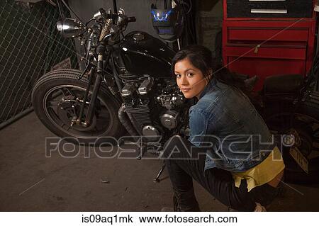 Female mechanic working on motorcycle in workshop View Large Photo Image Stock Image - Female mechanic working on motorcycle in workshop. Fotosearch