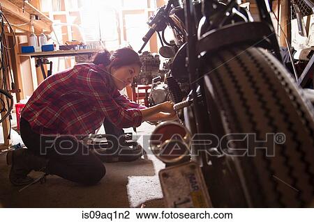 Female mechanic working on motorcycle in workshop View Large Photo Image Stock Image - Female mechanic working on motorcycle in workshop. Fotosearch