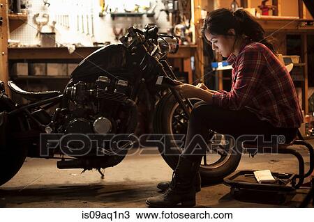 Female mechanic working on motorcycle in workshop View Large Photo Image Stock Image - Female mechanic working on motorcycle in workshop. Fotosearch