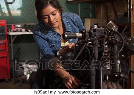 Female mechanic working on motorcycle in workshop View Large Photo Image Stock Photo - Female mechanic working on motorcycle in workshop. Fotosearch