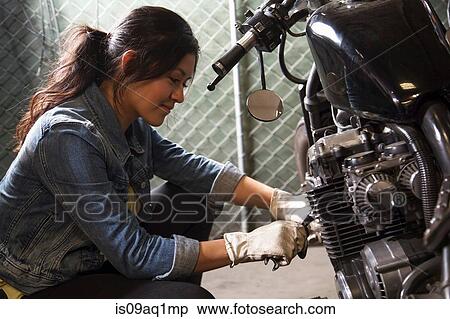 Female mechanic working on motorcycle in workshop View Large Photo Image Stock Photography - Female mechanic working on motorcycle in workshop. Fotosearch
