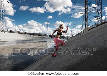 "Female runner running up steep river aquaduct, Los Angeles, California, USA" View Large Photo Image Picture - "Female runner running up steep river aquaduct, Los Angeles, California, USA". Fotosearch