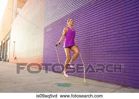 Female runner skipping on sidewalk View Large Photo Image Stock Image - Female runner skipping on sidewalk. Fotosearch