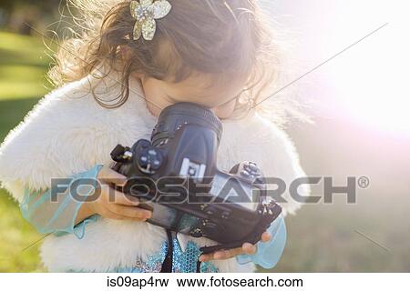 Female toddler in garden peering down into camera lens View Large Photo Image Stock Photo - Female toddler in garden peering down into camera lens. Fotosearch