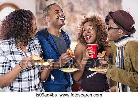 Four adult friends laughing and eating party food in kitchen View Large Photo Image Stock Photograph - Four adult friends laughing and eating party food in kitchen. Fotosearch