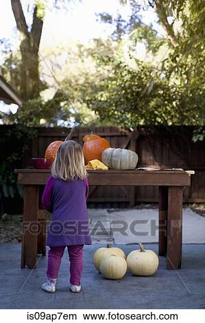 Girl carving pumpkin for Halloween View Large Photo Image Picture - Girl carving pumpkin for Halloween. Fotosearch