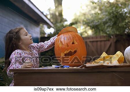 Girl carving pumpkin for Halloween View Large Photo Image Stock Photo - Girl carving pumpkin for Halloween. Fotosearch