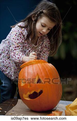 Girl carving pumpkin for Halloween View Large Photo Image Stock Photograph - Girl carving pumpkin for Halloween. Fotosearch