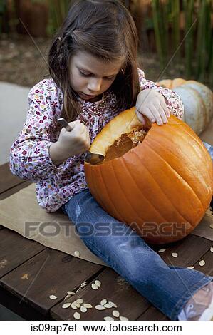 Girl carving pumpkin for Halloween View Large Photo Image Stock Photograph - Girl carving pumpkin for Halloween. Fotosearch