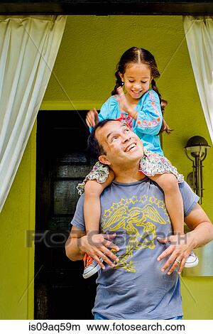 Girl getting a shoulder carry from father in garden porch View Large Photo Image Picture - Girl getting a shoulder carry from father in garden porch. Fotosearch