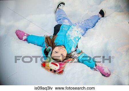 Stock Photo - Girl lying on snow. Fotosearch