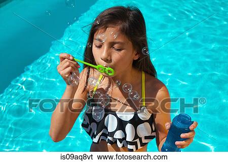 Stock Photograph - Girl waering bikini top with bubble wand. Fotosearch