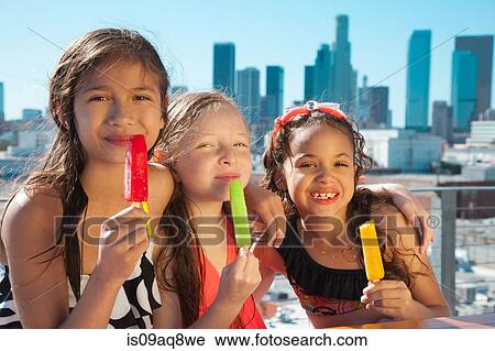 Stock Image - Girls eating ice lollies. Fotosearch