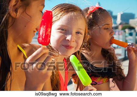 Stock Image - Girls eating ice lollies. Fotosearch