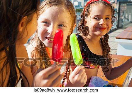 Girls eating ice lollies View Large Photo Image Stock Image - Girls eating ice lollies. Fotosearch