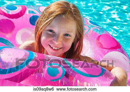 Girls in inflatable ring in swimming pool View Large Photo Image Stock Photograph - Girls in inflatable ring in swimming pool. Fotosearch