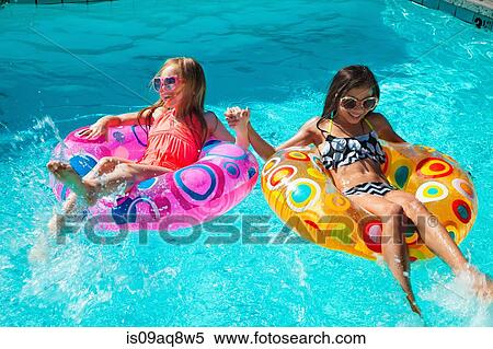 Girls in inflatable rings in swimming pool View Large Photo Image Stock Photography - Girls in inflatable rings in swimming pool. Fotosearch