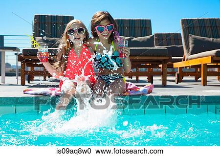 Girls sitting on poolside splashing water View Large Photo Image Stock Image - Girls sitting on poolside splashing water. Fotosearch
