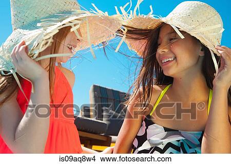 Girls wearing sunglasses and straw hats View Large Photo Image Picture - Girls wearing sunglasses and straw hats. Fotosearch